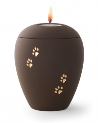 Tierurne aus samtener Keramik mit goldenen Pfoten in café mit Gedenklicht