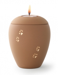 Tierurne aus samtener Keramik mit goldenen Pfoten in sand mit Gedenklicht