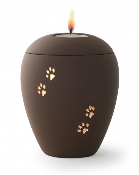 Tierurne aus samtener Keramik mit goldenen Pfoten in café mit Gedenklicht